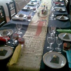 Table multicolore dorée et noire, composée d'une nappe noire, d'un chemin de table doré avec personnages et hiéroglyphes peints, de serviettes de différentes couleurs, de boîtes à bonbons pyramidales et d'une barque égyptienne remplie de bonbons.