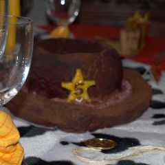 Gâteau en forme de chapeau de cow-boy et recouvert d'un glaçage au chocolat.