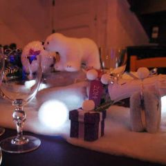 Centre de table constitué d'une composition de faux végétaux et confiseries s'écoulant par le fond d'une bouteille de champagne.